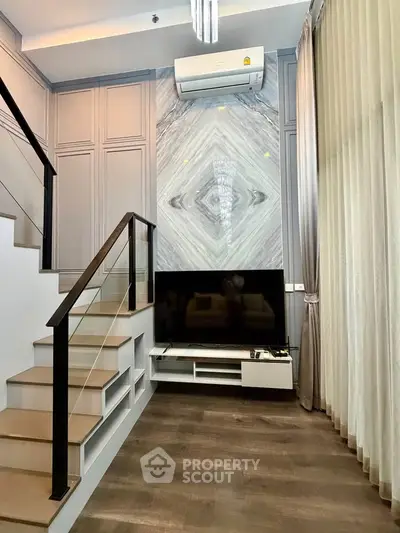 Modern living room with stylish staircase and sleek TV setup