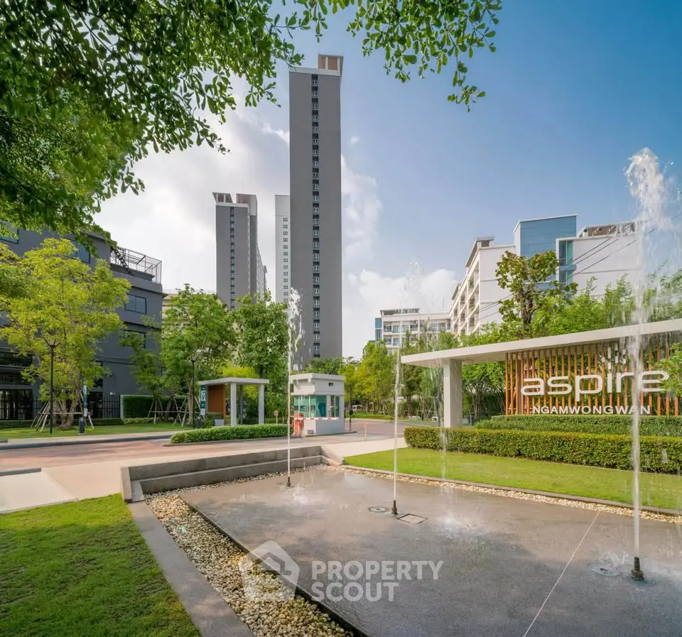 Modern residential complex with lush greenery and water features.