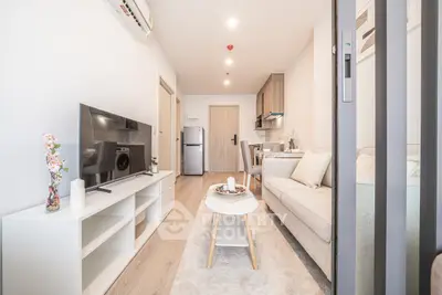 Modern living room with sleek furniture and open kitchen layout in a stylish apartment.