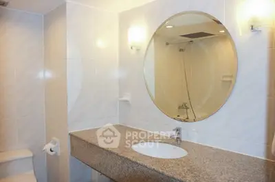 Modern bathroom with round mirror and granite countertop