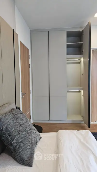 Modern bedroom with sleek built-in wardrobe and cozy bedding