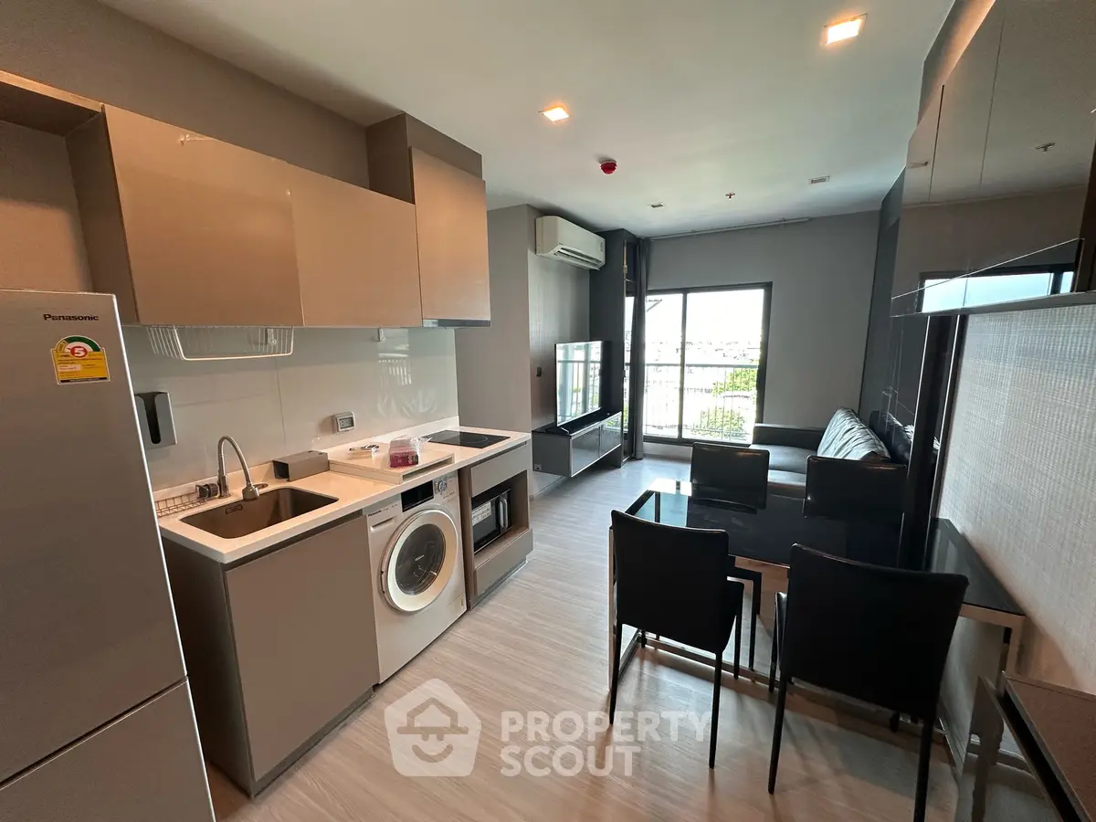 Modern open-layout kitchen and living room with sleek appliances and stylish furniture.