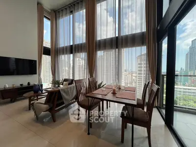 Luxurious high-rise living room with floor-to-ceiling windows and stunning city view.