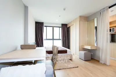 Modern studio apartment with cozy bedroom and dining area, featuring natural light and wooden accents.