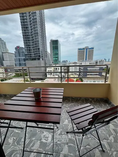 Stunning city view from a modern balcony with sleek furniture, perfect for urban living.