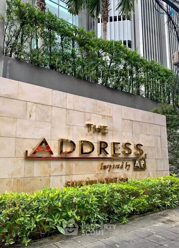 Luxurious entrance of The Address building with lush greenery and modern architecture.