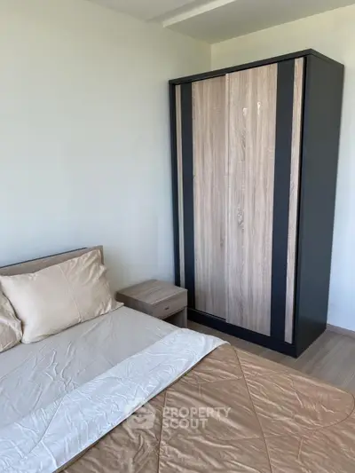 Modern bedroom with sleek wardrobe and cozy bedding in a stylish apartment.