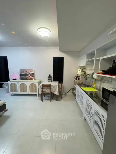 Modern open-layout living room with stylish furniture and sleek kitchen area.