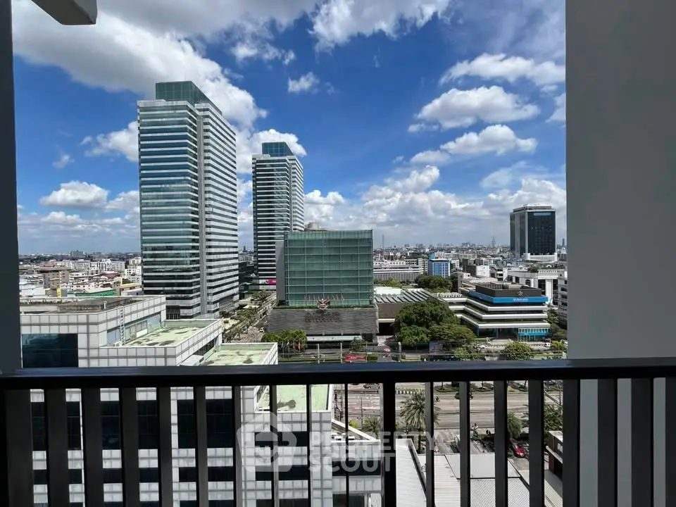 Stunning cityscape view from a high-rise balcony with modern skyscrapers under a clear blue sky.