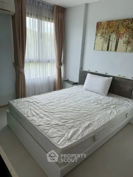 Cozy bedroom with large window and elegant decor, perfect for relaxation.