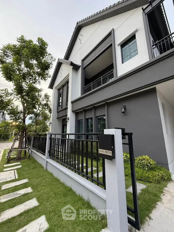 Modern two-story house with sleek design and lush green lawn