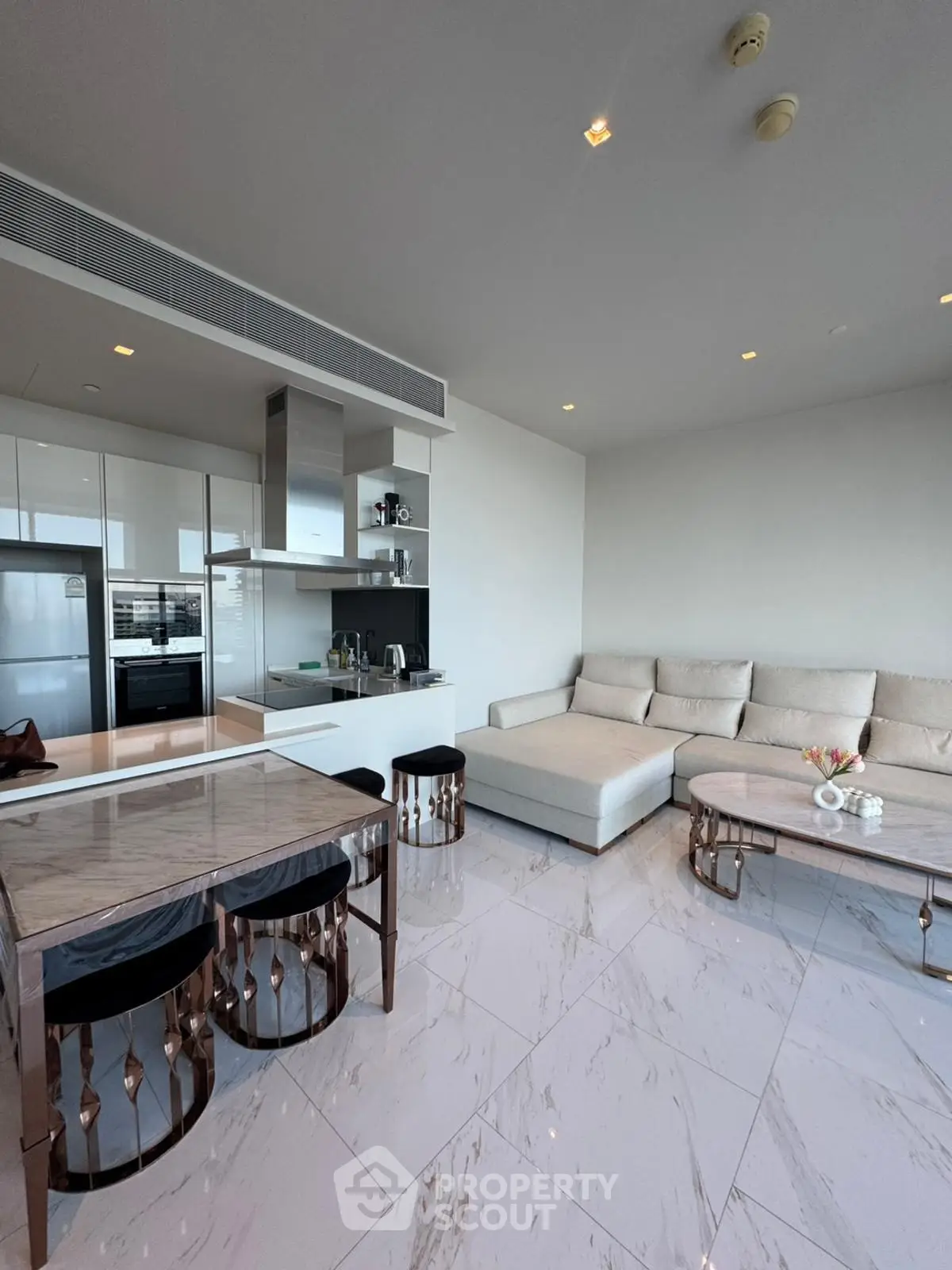 Luxurious modern living room with open kitchen and elegant marble flooring