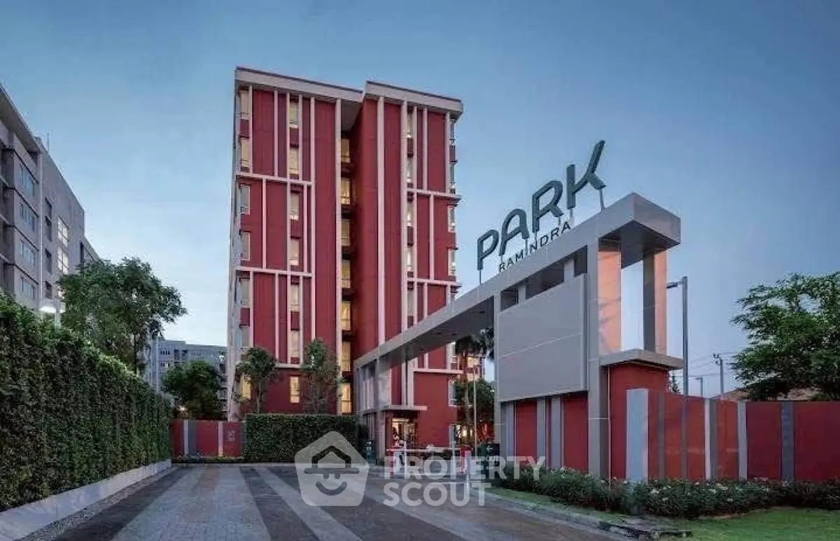 Modern apartment building with striking red facade and lush greenery at Park Bandra.
