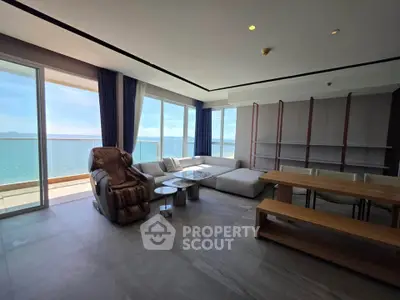 Luxurious living room with stunning ocean view and modern furniture in a high-rise apartment.