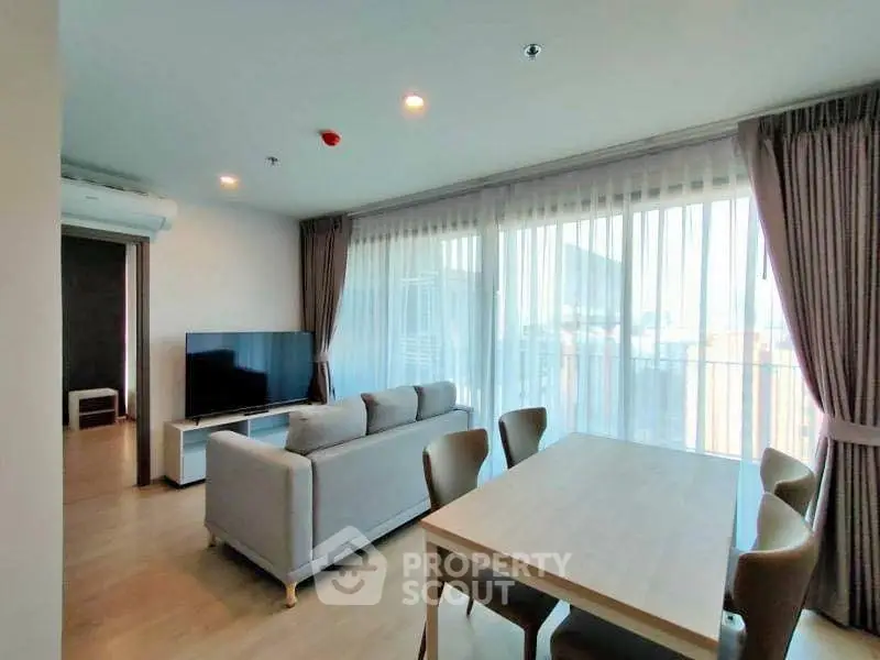 Spacious modern living room with large windows and elegant dining area