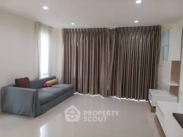 Spacious living room with modern sofa and elegant curtains