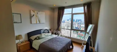 Stunning bedroom with panoramic city view, modern decor, and ample natural light.