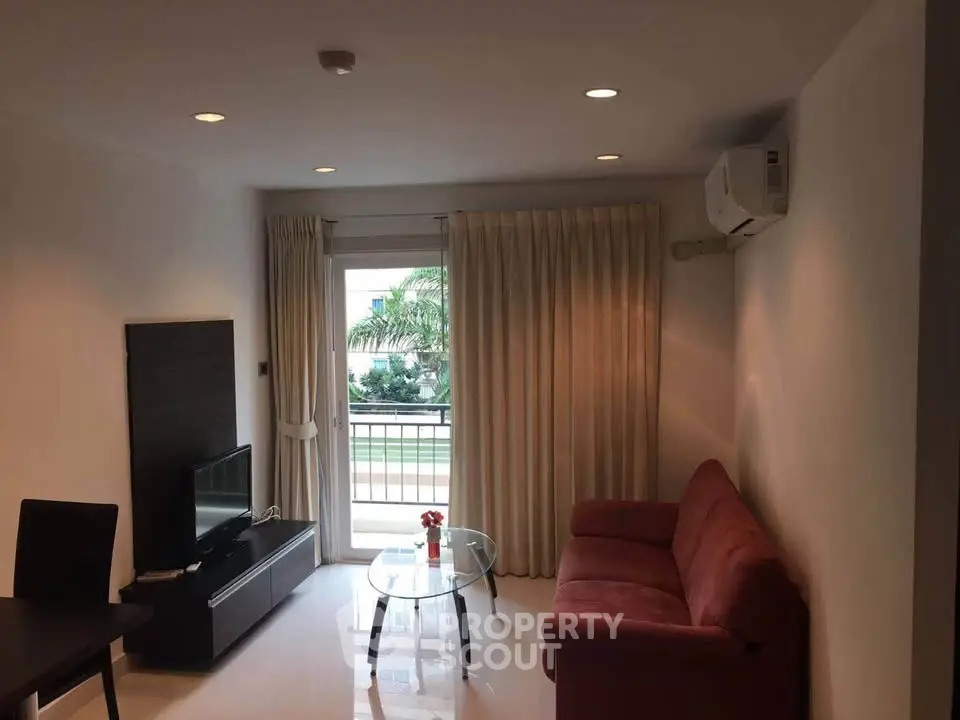 Modern living room with balcony view, featuring sleek furniture and natural light.