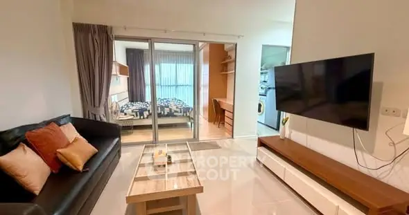 Modern living room with sleek TV setup and view into cozy bedroom