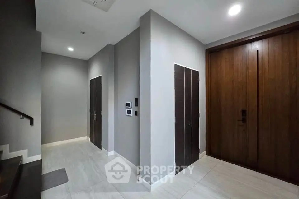 Modern apartment entrance with sleek wooden doors and minimalist design