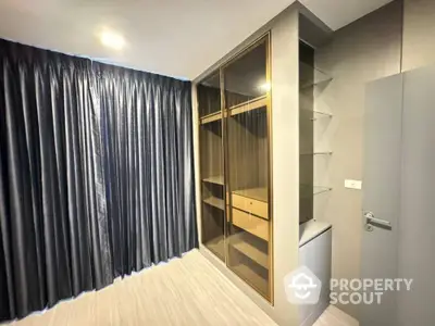 Modern bedroom with sleek built-in wardrobe and elegant gray curtains, offering a serene and organized living space.