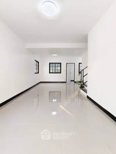 Spacious modern interior with sleek tile flooring and ample natural light.