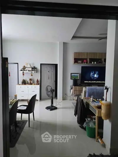 Modern living room with sleek furniture and wall-mounted TV, perfect for relaxation and entertainment.