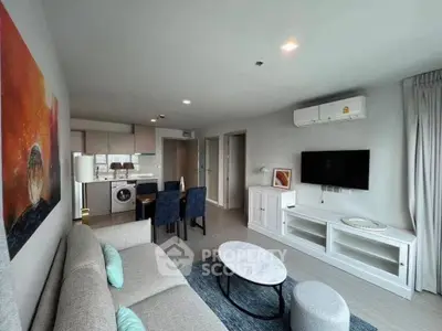 Modern living room with stylish decor, open kitchen, and cozy seating area in a contemporary apartment.