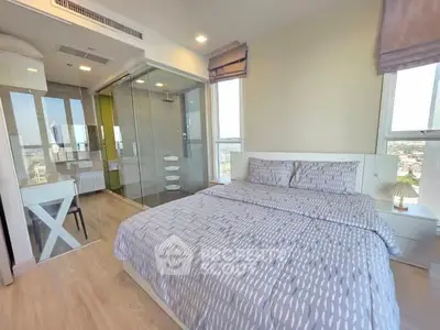 Modern bedroom with ensuite bathroom and city view, featuring stylish decor and ample natural light.
