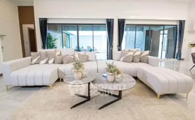 Luxurious modern living room with elegant curved sofa and stylish coffee tables.