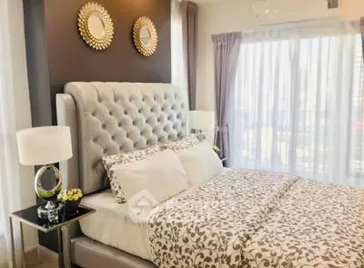 Luxurious bedroom with elegant decor and natural light, featuring a plush bed and stylish accents.