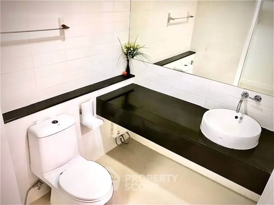 Modern bathroom with sleek black countertop and white fixtures