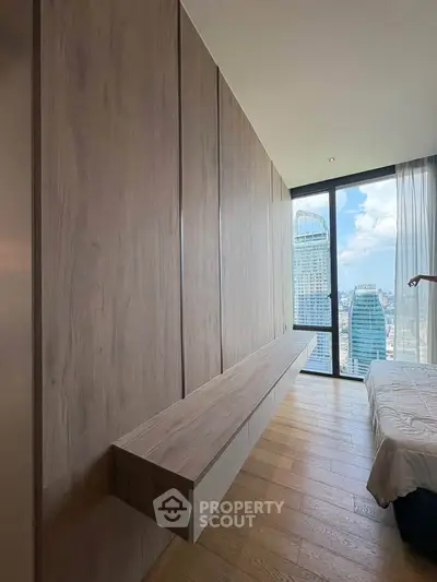 Modern bedroom with floor-to-ceiling windows offering stunning city views and sleek wooden paneling.