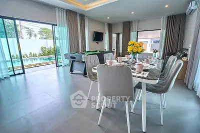 Spacious living room with pool view, modern dining area, and entertainment setup.