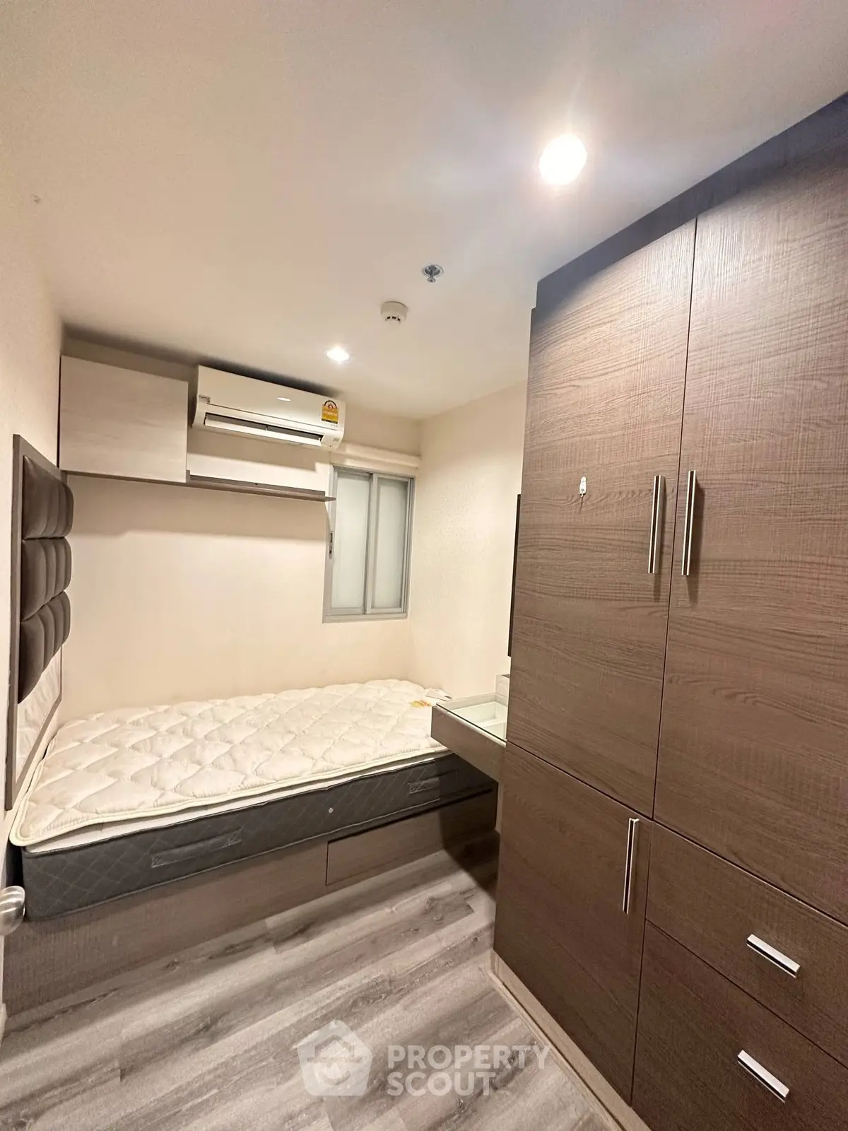 Compact bedroom with built-in wardrobe and air conditioning unit
