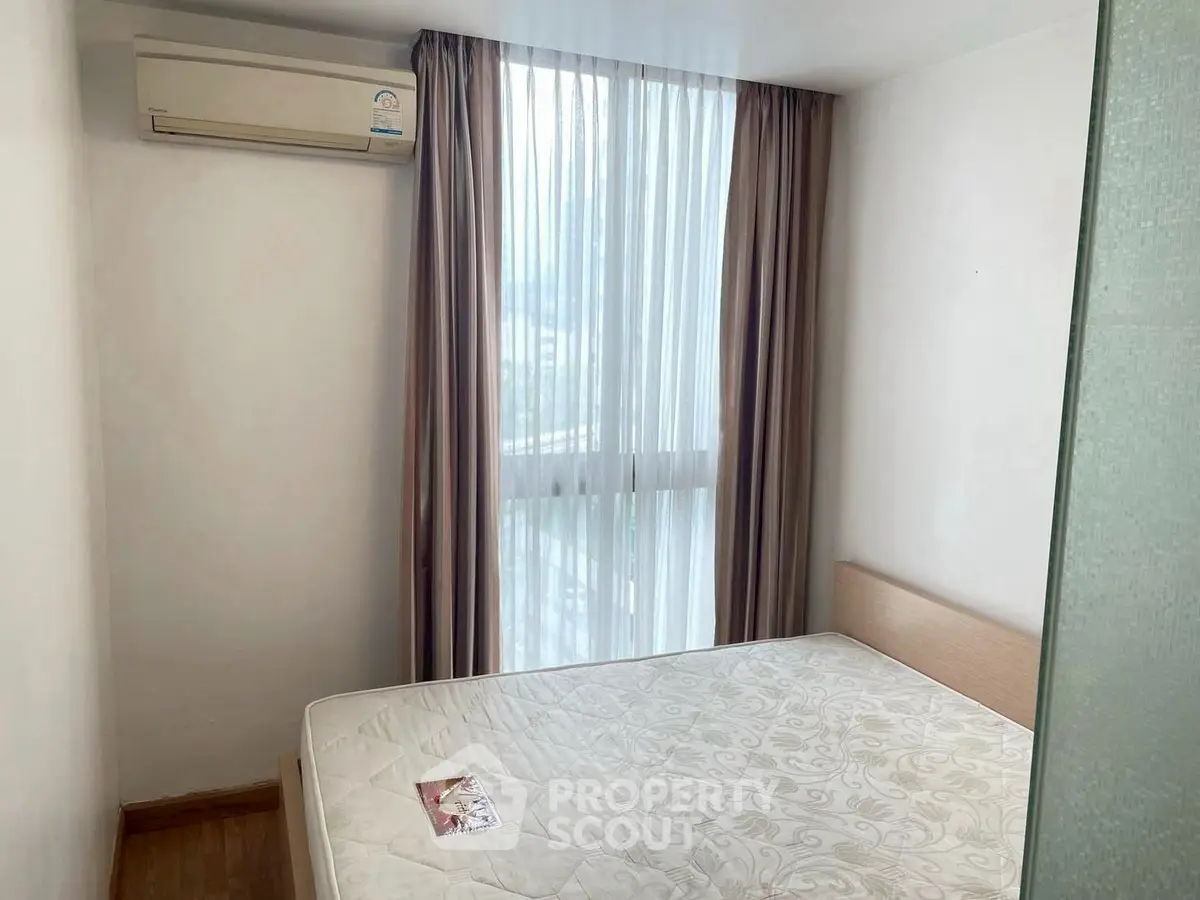 Cozy bedroom with air conditioning and large window for natural light