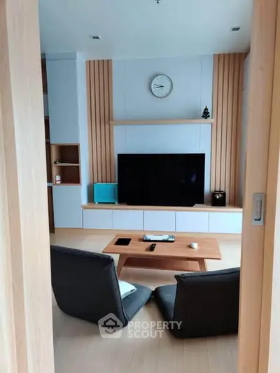 Modern living room with sleek furniture and large TV, perfect for relaxation and entertainment.