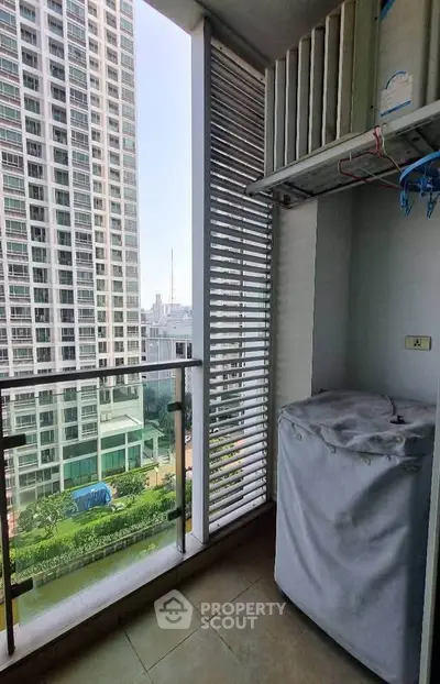 Modern high-rise balcony with city view and laundry area, perfect for urban living.