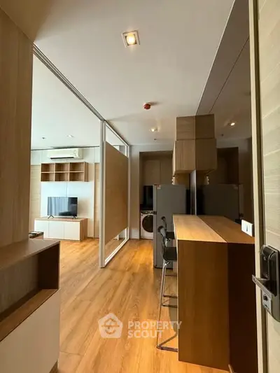 Modern open-concept living space with wooden flooring and stylish furniture