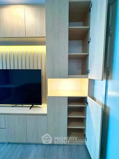 Modern living room with built-in wooden cabinets and TV, showcasing sleek storage solutions.