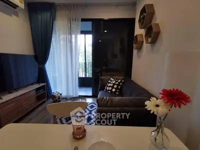 Stylish living room with modern decor and balcony view in a cozy apartment.