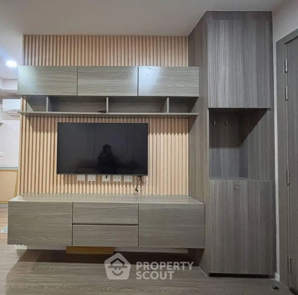 Modern living room with sleek wooden TV unit and ample storage space.