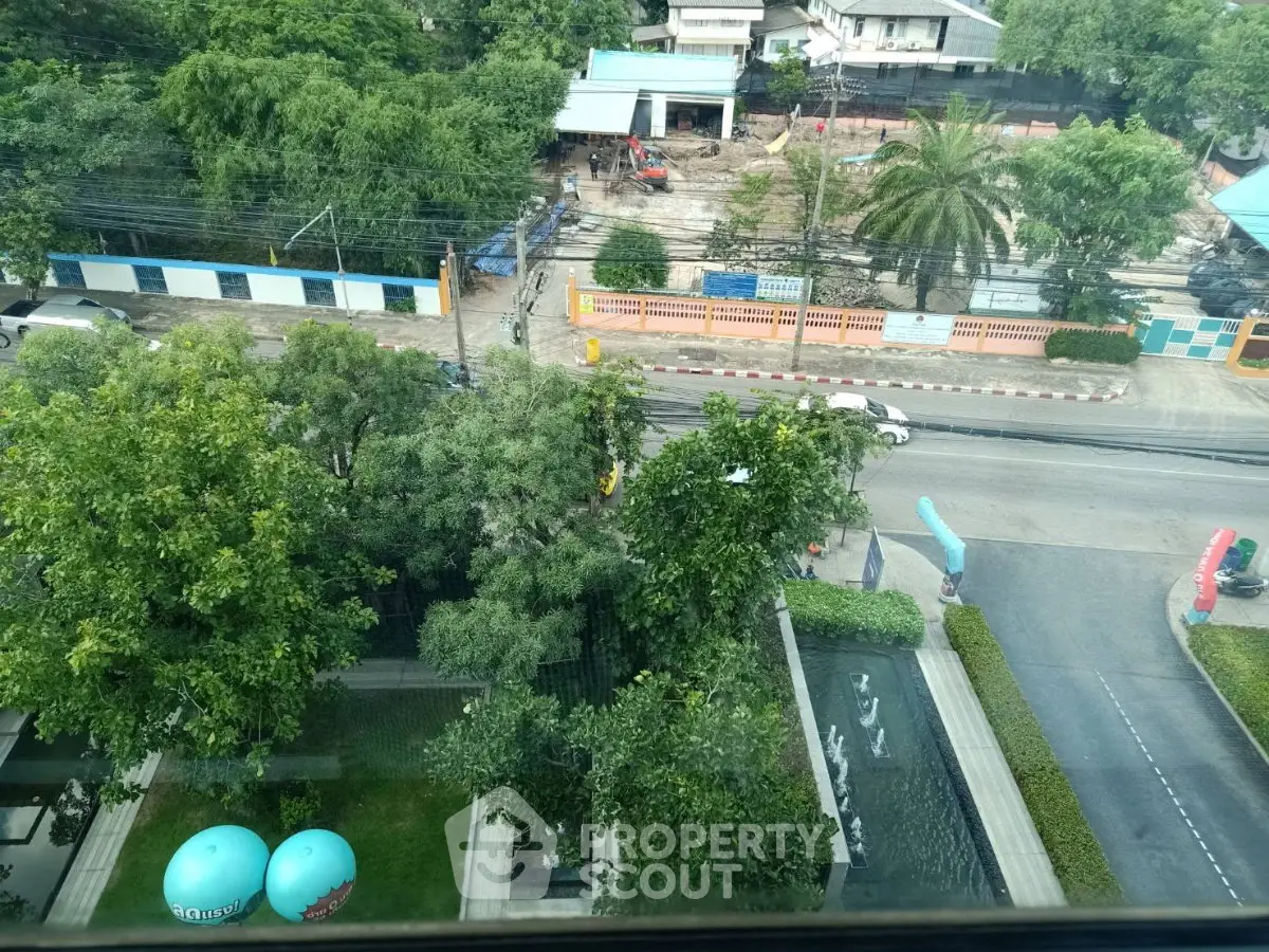 Aerial view of lush garden and modern building entrance with water features.