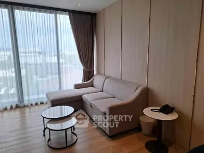 Modern living room with large windows and stylish furniture in a high-rise apartment.