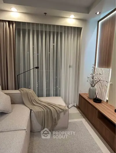 Cozy living room with modern decor and soft lighting, featuring a comfortable sofa and elegant curtains.