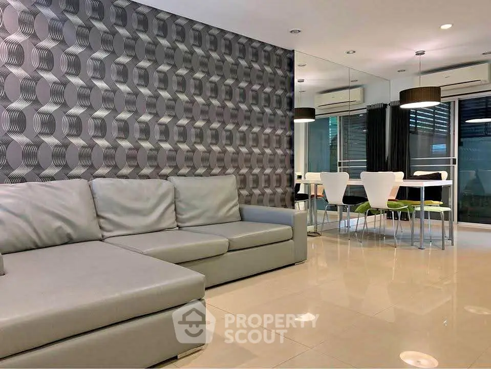 Modern living room with stylish geometric wallpaper and sleek dining area