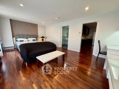 Spacious modern bedroom with elegant wooden flooring and stylish decor