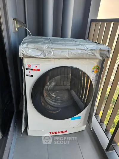 Modern balcony with a Toshiba washing machine and city view, perfect for urban living convenience.