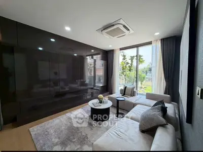 Modern living room with sleek design, large windows, and stylish furniture in a luxury apartment.