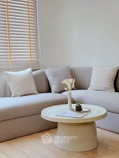 Modern living room with stylish sofa and round coffee table, perfect for relaxation.